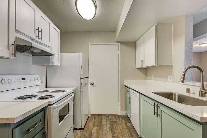 Modern kitchen with sleek white cabinetry, spacious countertops, and stainless steel appliances, perfect for gourmet cooking.