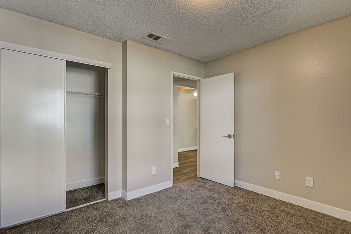 Inviting bedroom featuring plush carpeting, neutral walls, and a spacious closet for ample storage.