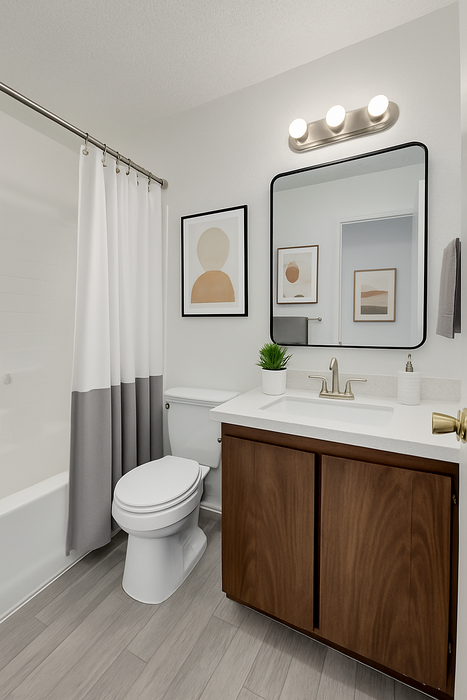 Contemporary bathroom with sleek fixtures, elegant framed art, and chic lighting, showcasing style and comfort.