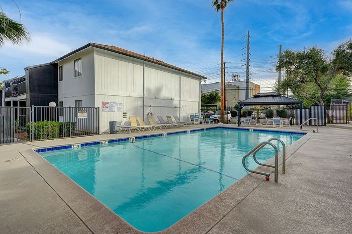 Inviting residential swimming pool area with cozy lounge chairs, perfect for relaxation and enjoying sunny days.