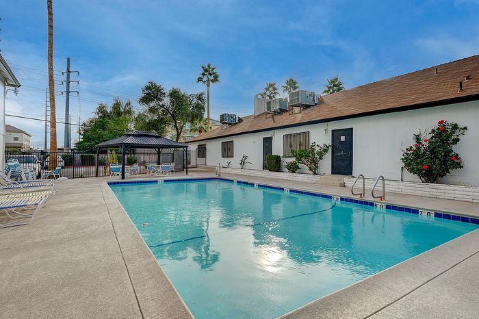 Inviting outdoor swimming pool with lounging chairs and a charming gazebo, perfect for relaxation.