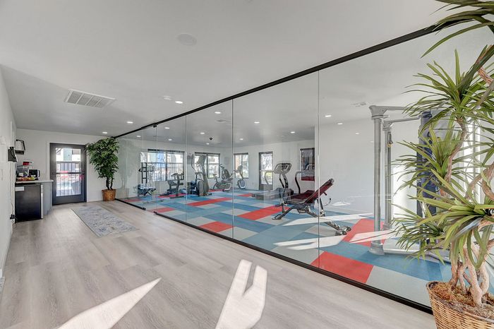 Sleek and modern fitness center with vibrant flooring, glass walls, and state-of-the-art equipment, inviting for a refreshing workout experience.