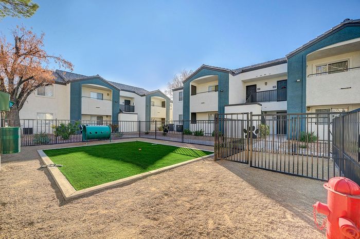 Charming apartment complex with manicured lawns, modern balconies, and vibrant outdoor play area, perfect for families and pet-friendly living.