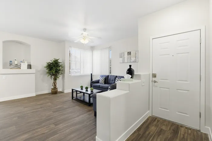 Modern living room with elegant decor, featuring a cozy sofa, chic coffee table, and natural light from large windows.