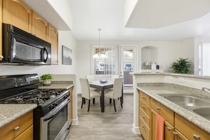 Inviting kitchen and dining area with modern appliances, warm wood cabinets, and a cozy breakfast nook.