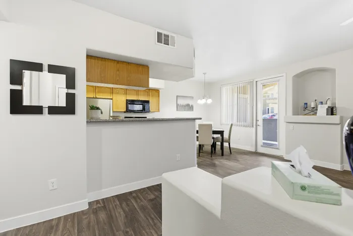 Modern open-concept living space with elegant kitchen and dining area featuring chic fixtures and natural lighting.
