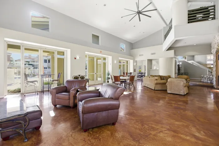 Spacious and elegant open-concept living area with high ceilings, modern furnishings, and large windows offering abundant natural light.