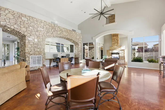 Luxurious communal area with stone walls, modern fireplace, and large windows offering natural light, perfect for relaxation and social gatherings.