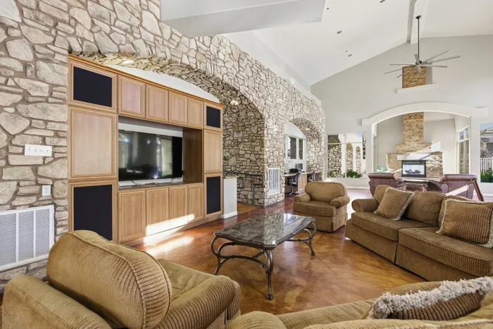 Luxurious living room with stone walls, elegant fireplace, and plush seating, perfect for relaxation and entertainment.