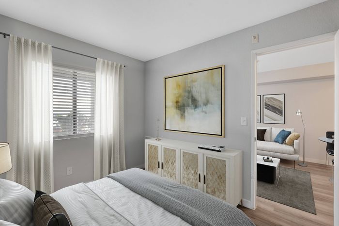 Bright and cozy bedroom with elegant decor and views into a modern, inviting living area.