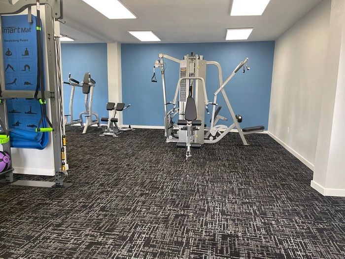 Contemporary gym space with state-of-the-art exercise equipment and calming blue accent walls.