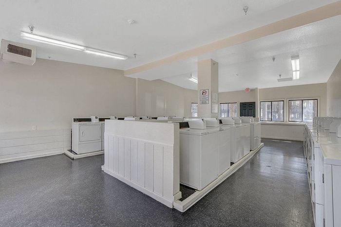 Bright and spacious laundry room with multiple washing machines, perfect for efficient and convenient laundry days.