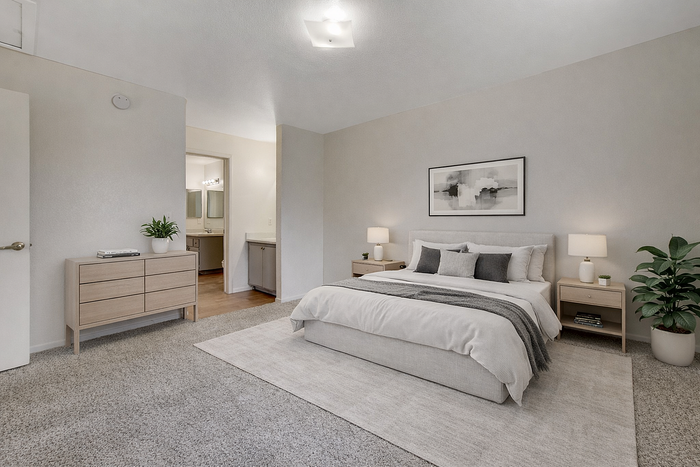 Modern and spacious bedroom with elegant decor, featuring a cozy bed, stylish nightstands, and inviting lighting connected to a sleek en-suite bathroom.