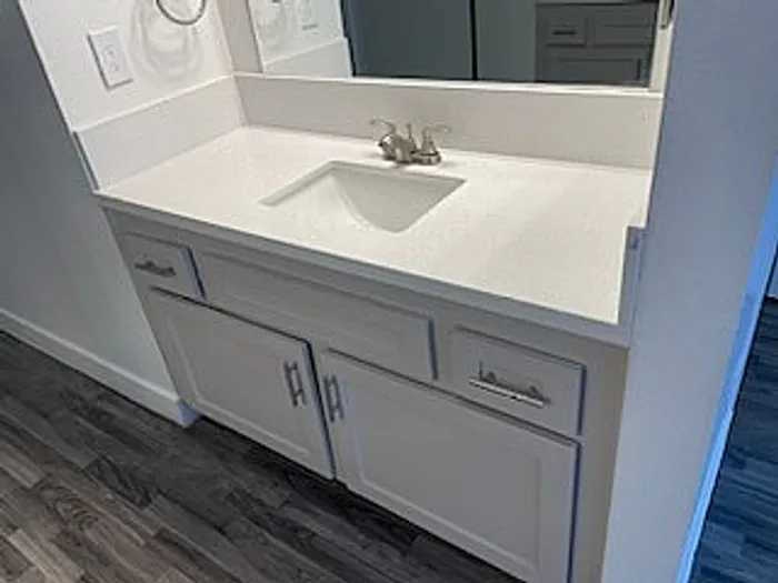 Modern bathroom vanity with sleek countertop and ample storage, set against elegant gray flooring.