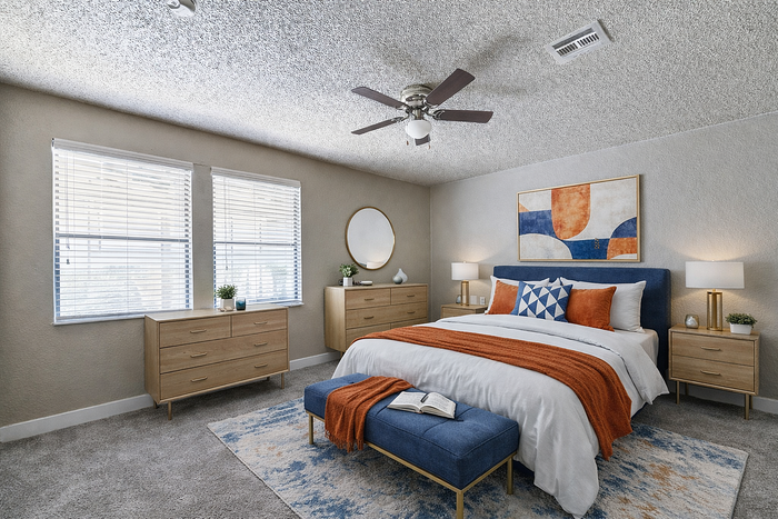 Modern and cozy bedroom with elegant decor, featuring a plush blue headboard, vibrant artwork, and stylish furnishings.
