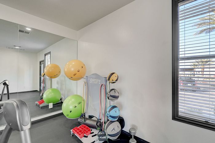 Bright and modern fitness area with exercise balls, resistance bands, and gym equipment, perfect for home workouts.