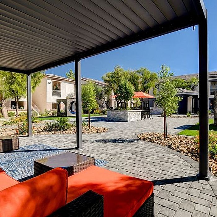 Inviting outdoor patio space with vibrant seating, surrounded by lush greenery and modern architecture.
