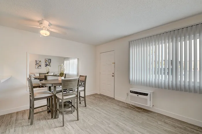 Bright dining area with elegant wood flooring, modern table set, and large window for natural light.