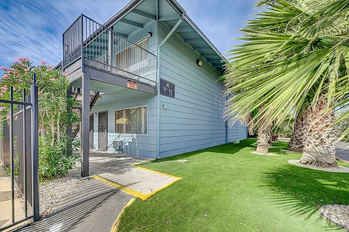 Charming apartment exterior with lush landscaping and vibrant natural light, highlighting the two-story structure and inviting entrance.