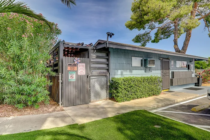 Charming community building nestled in lush greenery with a welcoming entrance and modern exterior.