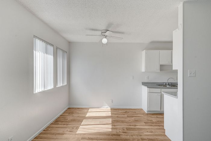 Bright and airy apartment with elegant wood floors, modern kitchen space, and large windows for natural light.