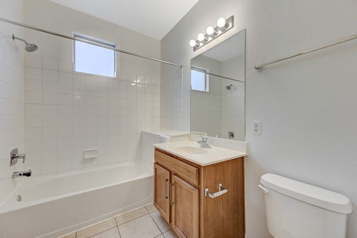 Bright and modern bathroom with elegant vanity, sleek fixtures, and spacious bathtub for ultimate relaxation.