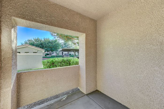 Inviting apartment patio with a scenic view of lush greenery, perfect for outdoor relaxation.