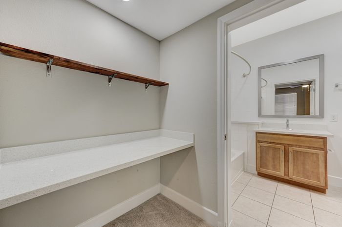 Modern apartment interior featuring a stylish bathroom with a wooden vanity, sleek countertop, and a spacious shelf area.