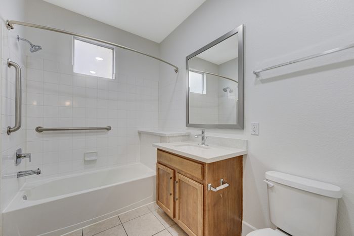 Bright and inviting bathroom with elegant fixtures, a soaking tub, and contemporary vanity for a modern touch.