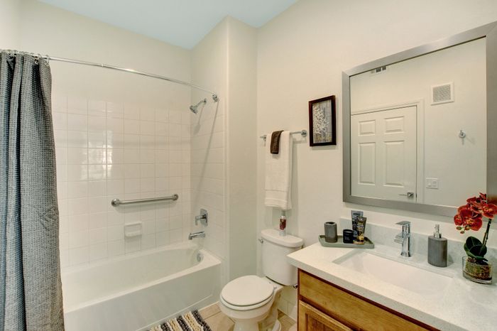 Elegant bathroom with a sleek countertop, bathtub, and modern fixtures, offering a serene and stylish retreat.