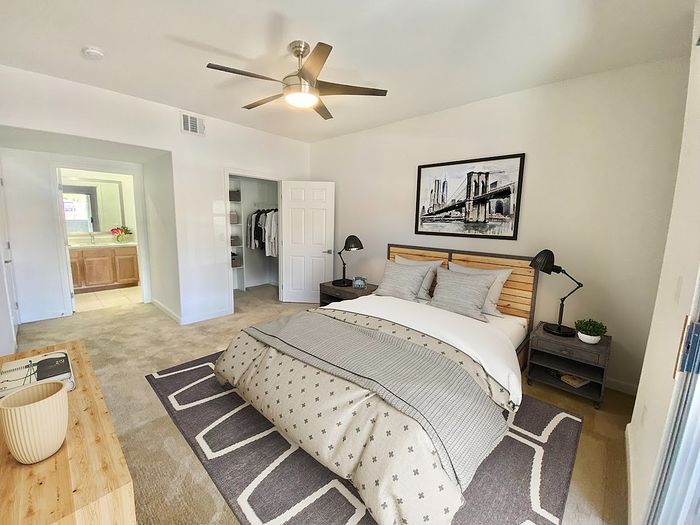 Inviting bedroom featuring a cozy bed, elegant decor, and ensuite access with a modern, neutral palette.