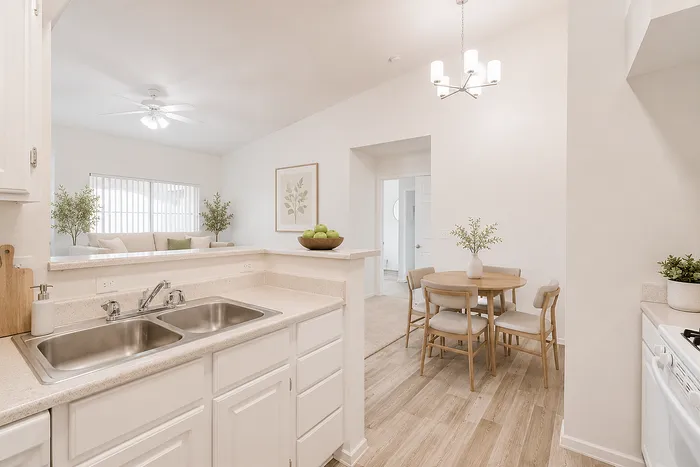 Inviting open kitchen and dining area with modern fixtures, elegant lighting, and natural wood flooring, exuding warmth and style.