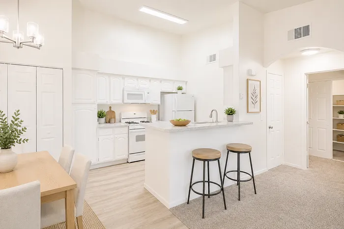 Bright and modern kitchen with white cabinetry, inviting breakfast bar with stools, and elegant dining area.