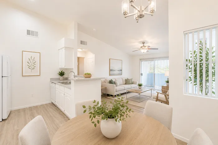 Bright, airy open-concept living area with modern kitchen, elegant dining space, and cozy living room leading to a sunlit balcony.