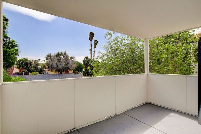 Charming balcony with lush greenery views, perfect for relaxing in the serene outdoors.