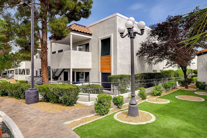 Charming apartment exterior showcasing modern architecture and lush landscaping, perfect for a serene living experience.
