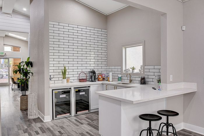 Modern kitchen with sleek white countertops, stylish subway tile backsplash, and elegant bar seating.