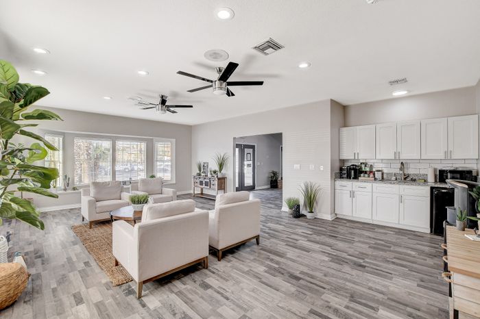 Bright, modern living space with cozy seating, sleek hardwood floors, and a stylish open kitchen.
