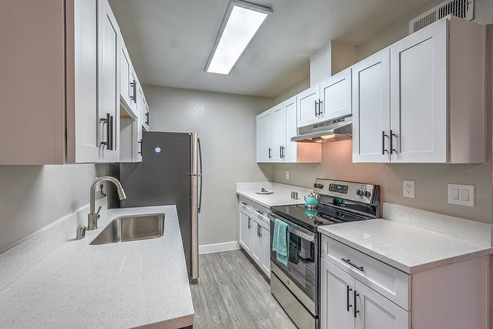 Elegant kitchen with modern white cabinetry, sleek countertops, and stainless steel appliances offering a bright and functional space.