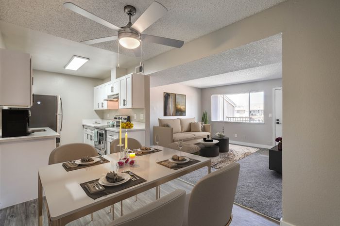 Modern open-plan apartment with sleek kitchen, elegant dining area, and cozy living space featuring natural light and stylish decor.