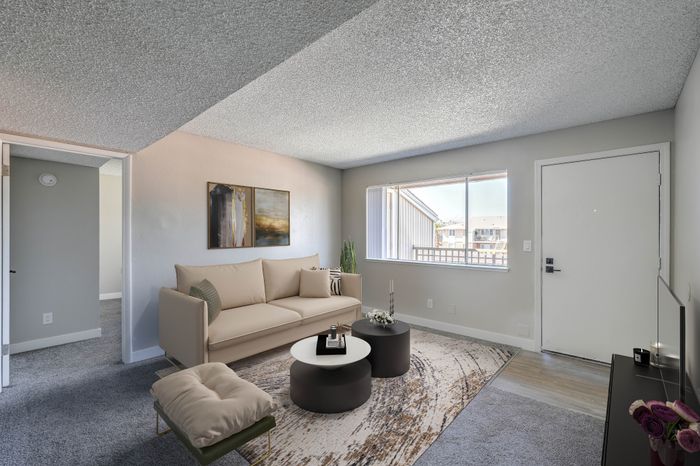 Inviting living room with modern decor, bright natural light, and stylish furniture, perfect for relaxation.