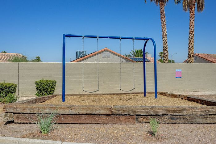 Inviting playground with a bright blue swing set nestled under sunny skies, offering a perfect outdoor space for families.