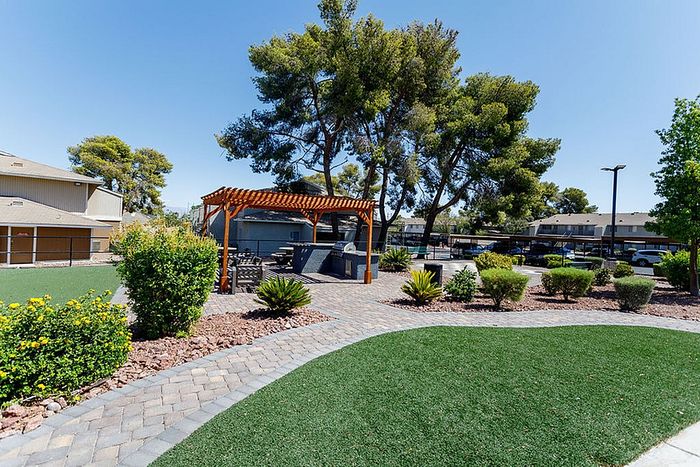 Charming outdoor space with lush greenery, a stylish pergola, and inviting seating, perfect for relaxation and gatherings.