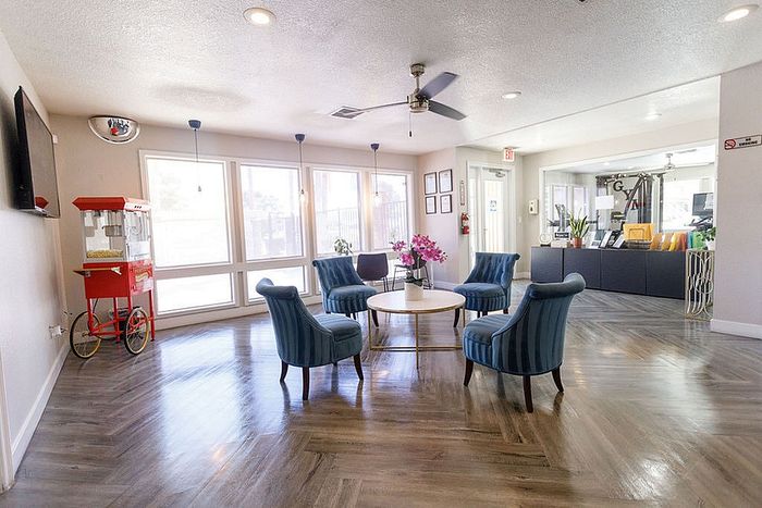 Inviting lounge area with elegant blue chairs, vibrant floral centerpiece, and modern popcorn machine, perfect for entertainment and relaxation.