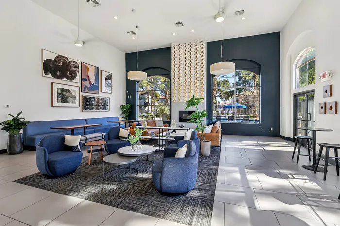 Modern and inviting lounge area featuring stylish seating, contemporary artwork, and large windows flooding the space with natural light.