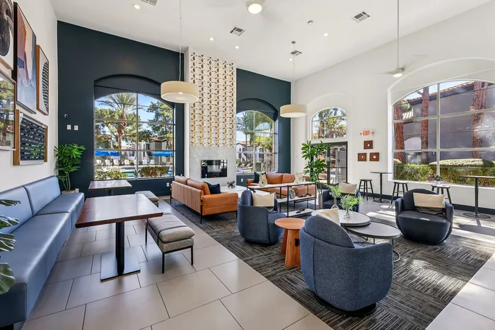 Modern and inviting apartment lounge with stylish seating, vibrant artwork, and large windows offering a scenic view.