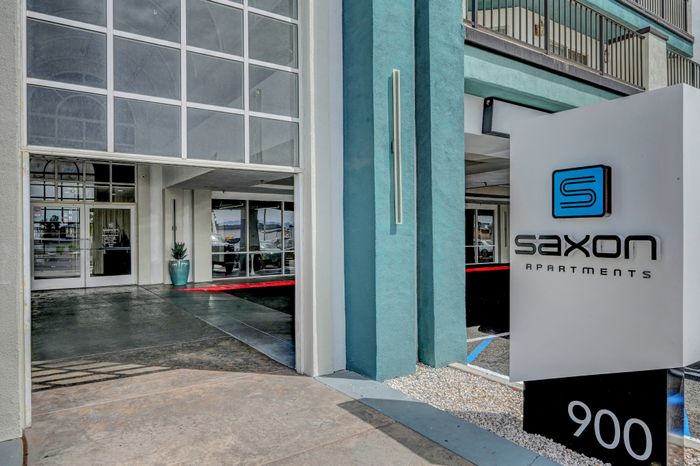 Welcoming entrance to Saxon Apartments with modern architecture and stylish signage.