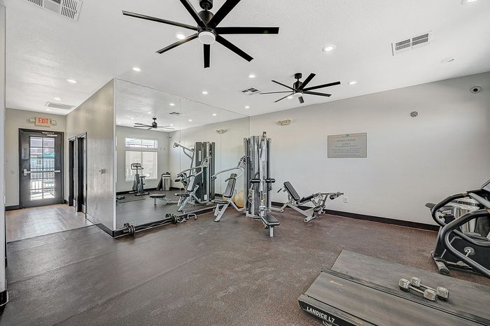 Modern fitness center featuring state-of-the-art exercise equipment, mirrored walls, and ample natural light.