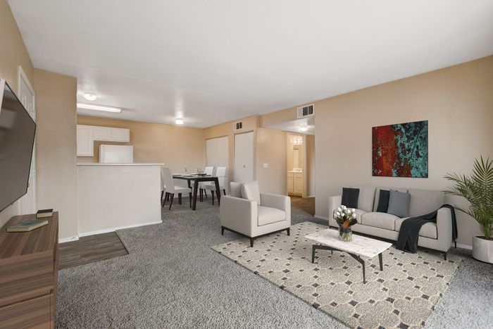 Inviting open-plan living room featuring cozy seating, elegant decor, and a sleek kitchen with modern appliances.
