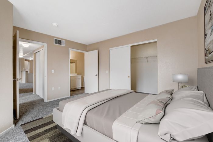 Inviting bedroom with modern decor, plush carpet, and ample closet space for comfortable living.